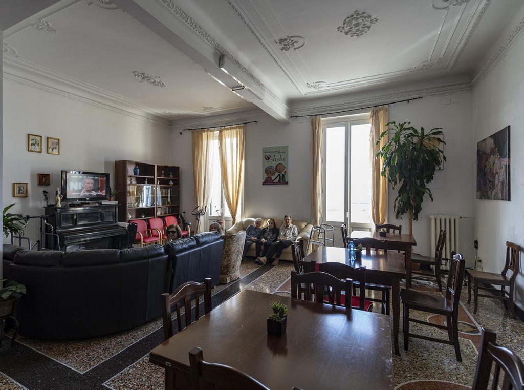Il salotto della Residenza Archè, con ampie finestre, divani, tavoli e pianoforte